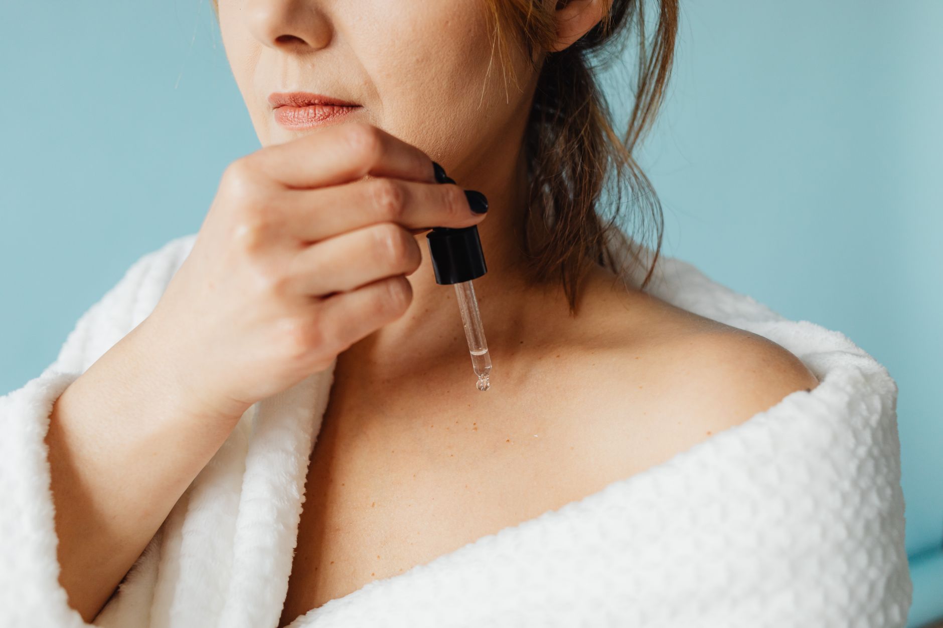 Application d'huile végétale sur le visage avec compte-gouttes