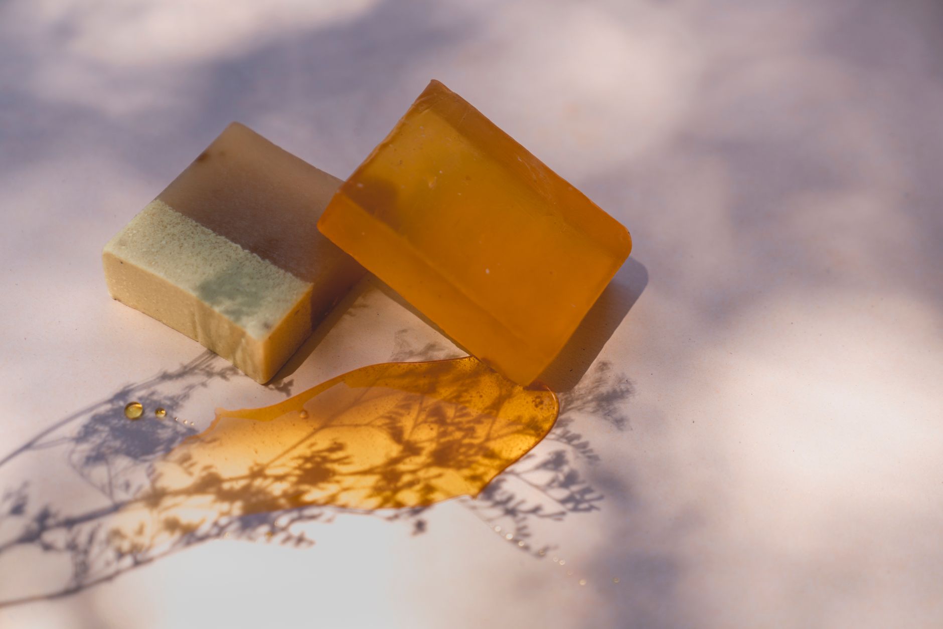 Un savon glycériné translucide posé à côté d'un savon opaque, contraste de texture entre les deux procédés